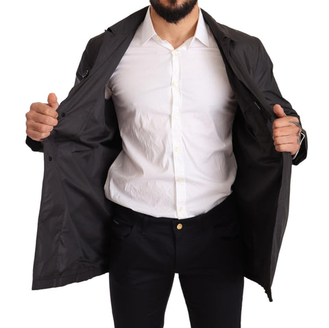Black polyester men's trench coat jacket by Dolce & Gabbana, shown with classic double-breasted design and belted waist.