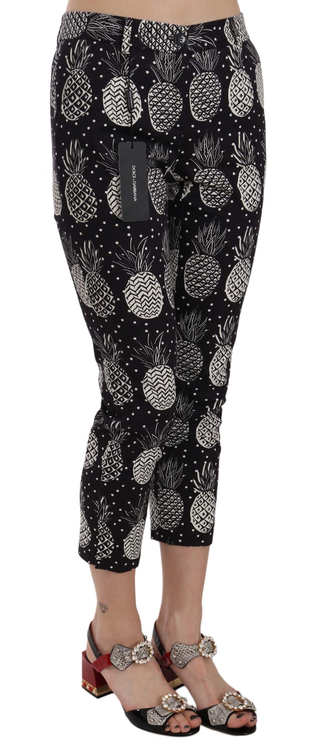 Black pineapple print skinny Capri pants by Dolce & Gabbana, featuring a vibrant tropical pattern and fitted silhouette.