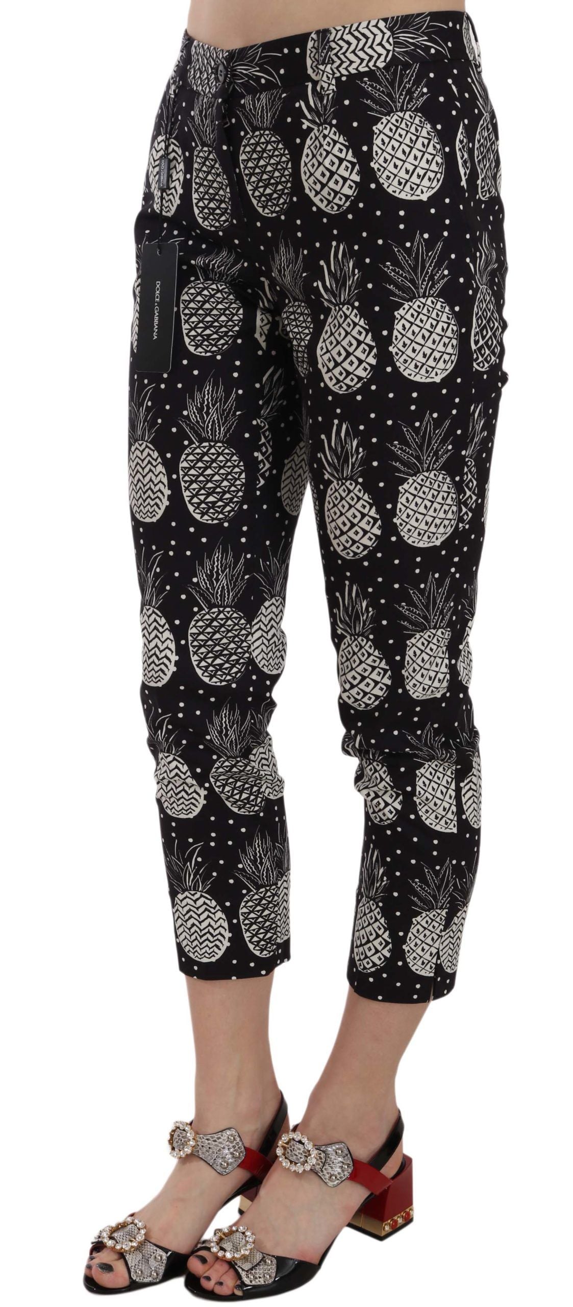 Black pineapple print Dolce & Gabbana skinny Capri pants with fitted style and vibrant tropical pattern on lightweight fabric.