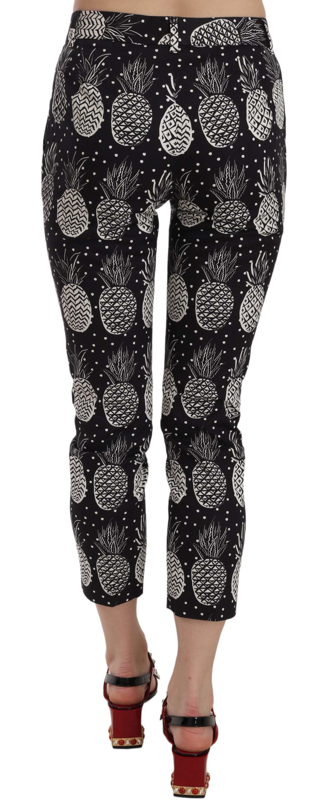 Black pineapple print skinny Capri pants by Dolce & Gabbana, featuring a fitted silhouette and tropical fruit pattern.