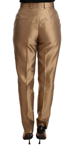 Gold silk tapered trousers with metallic finish from Dolce & Gabbana, displayed on a model.