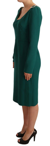 Green stretch crepe crystal midi dress by Dolce & Gabbana hanging on a clothing rack with intricate crystal details
