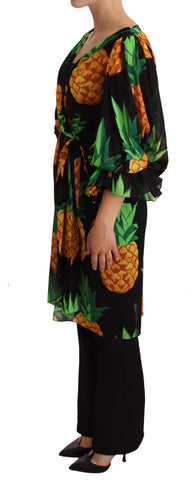 Black silk wrap dress with a vibrant pineapple print by Dolce & Gabbana, featuring long sleeves and a fitted silhouette.