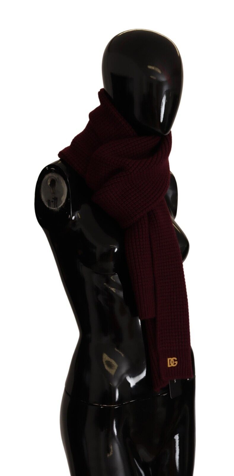 Dark red Dolce & Gabbana cashmere wrap shawl with logo knit pattern, draped over a neutral background, showcasing soft luxury and craftsmanship.