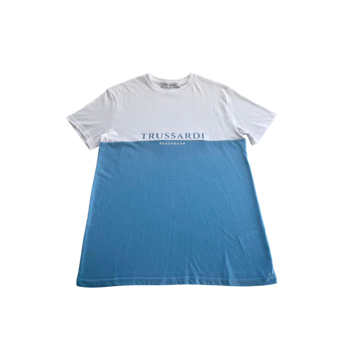 White and azure Trussardi beachwear top with stylish design, displayed on a model against a beach background.