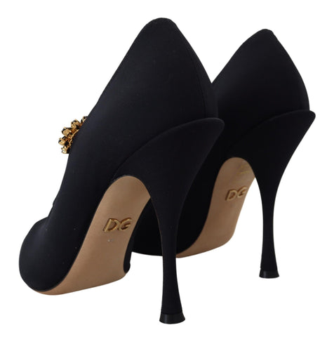 Black Dolce & Gabbana stretch crystal pumps with black socks, featuring elegant design and pointed toes.