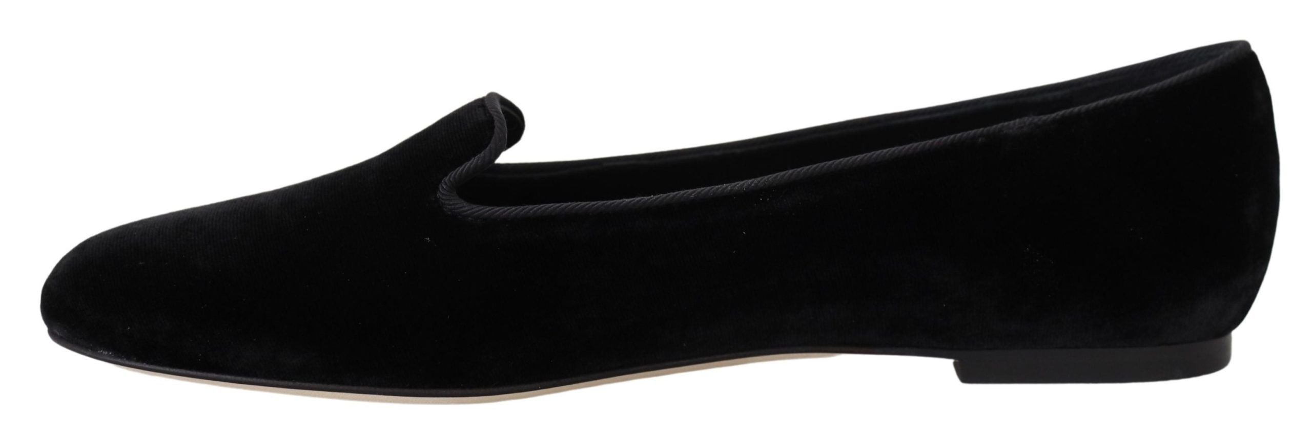 Black velvet slip-on loafers by Dolce & Gabbana, showing the elegant flat shoes with a sleek design and polished finish.
