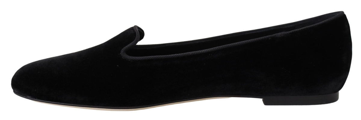 Black velvet slip-on loafers by Dolce & Gabbana, showing the elegant flat shoes with a sleek design and polished finish.