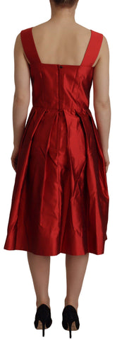 Red Dolce & Gabbana A-line pleated satin silk dress displayed on a mannequin with a flowing skirt and elegant design.