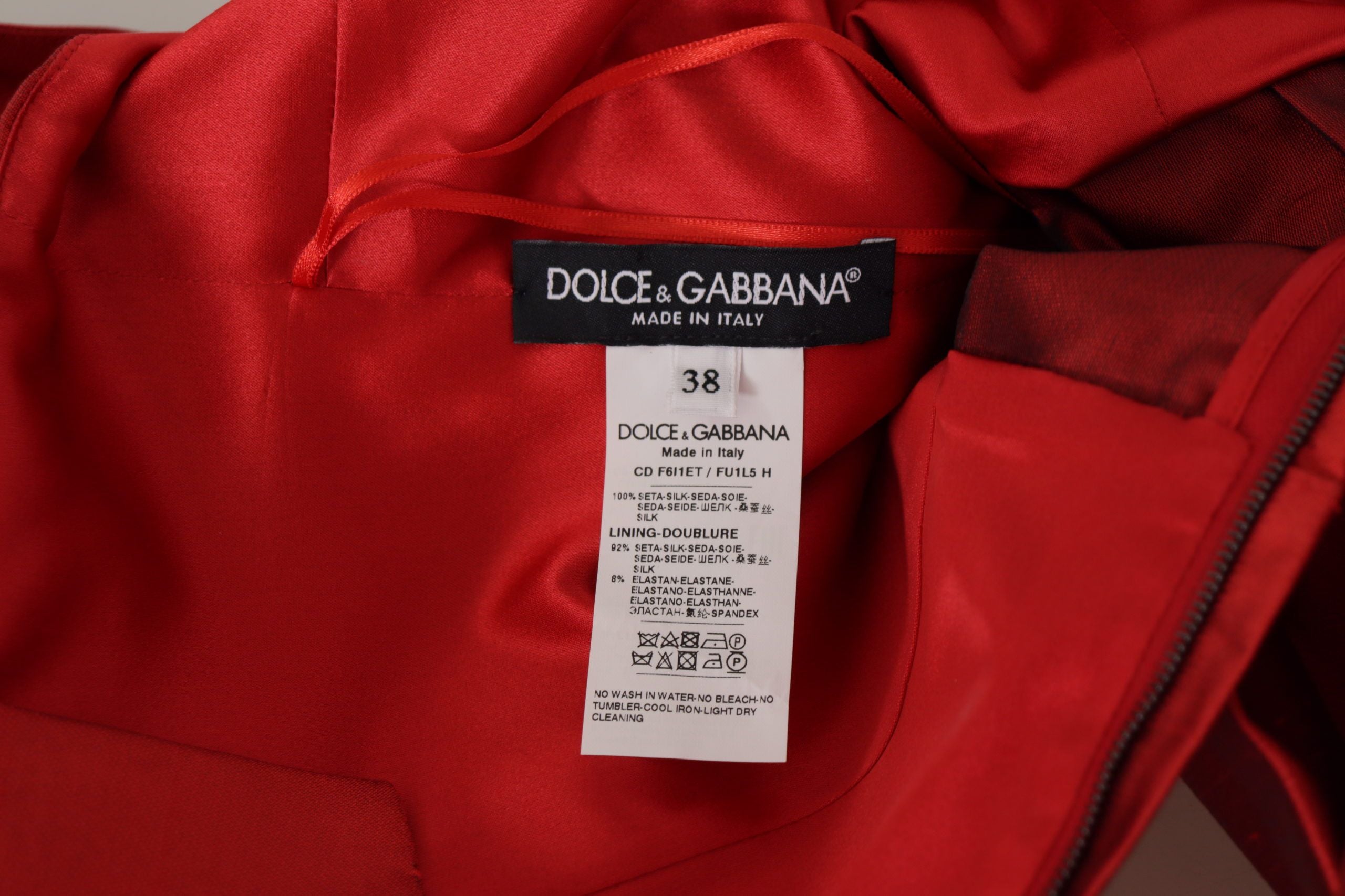 Red A-line pleated satin silk dress by Dolce & Gabbana, featuring a fitted bodice and flowing skirt.