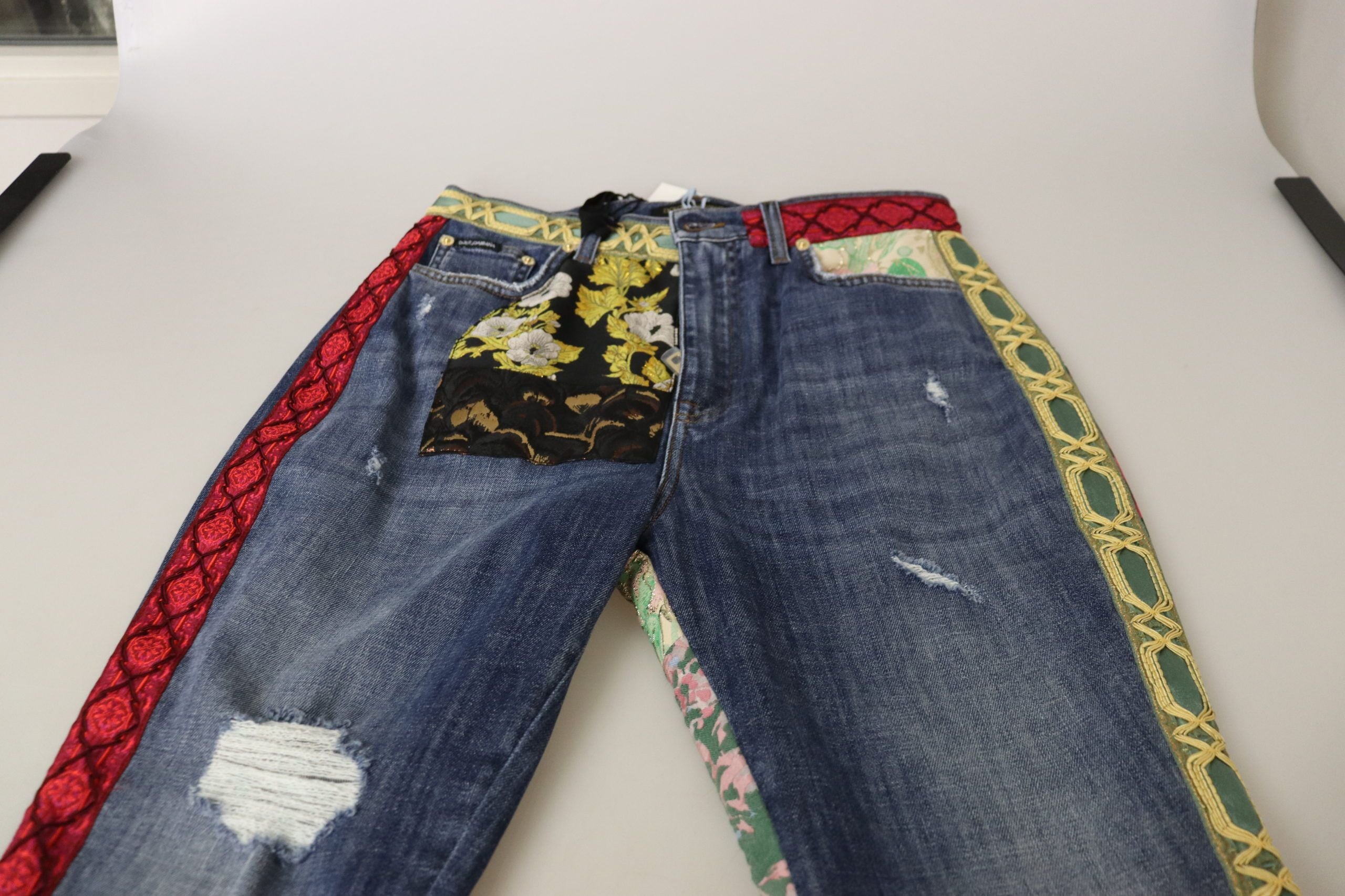 Blue patchwork high waist denim jeans by Dolce & Gabbana, shown with detailed stitching and fitted silhouette.