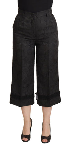 Black brocade cropped high waist pants by Dolce & Gabbana, featuring intricate fabric design and tailored fit.