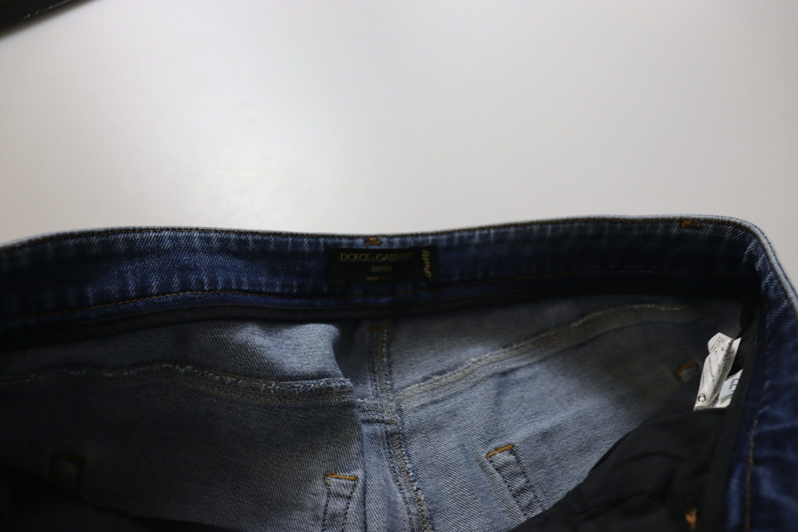 Blue washed cotton skinny low waist denim jeans by Dolce & Gabbana displayed on a hanger