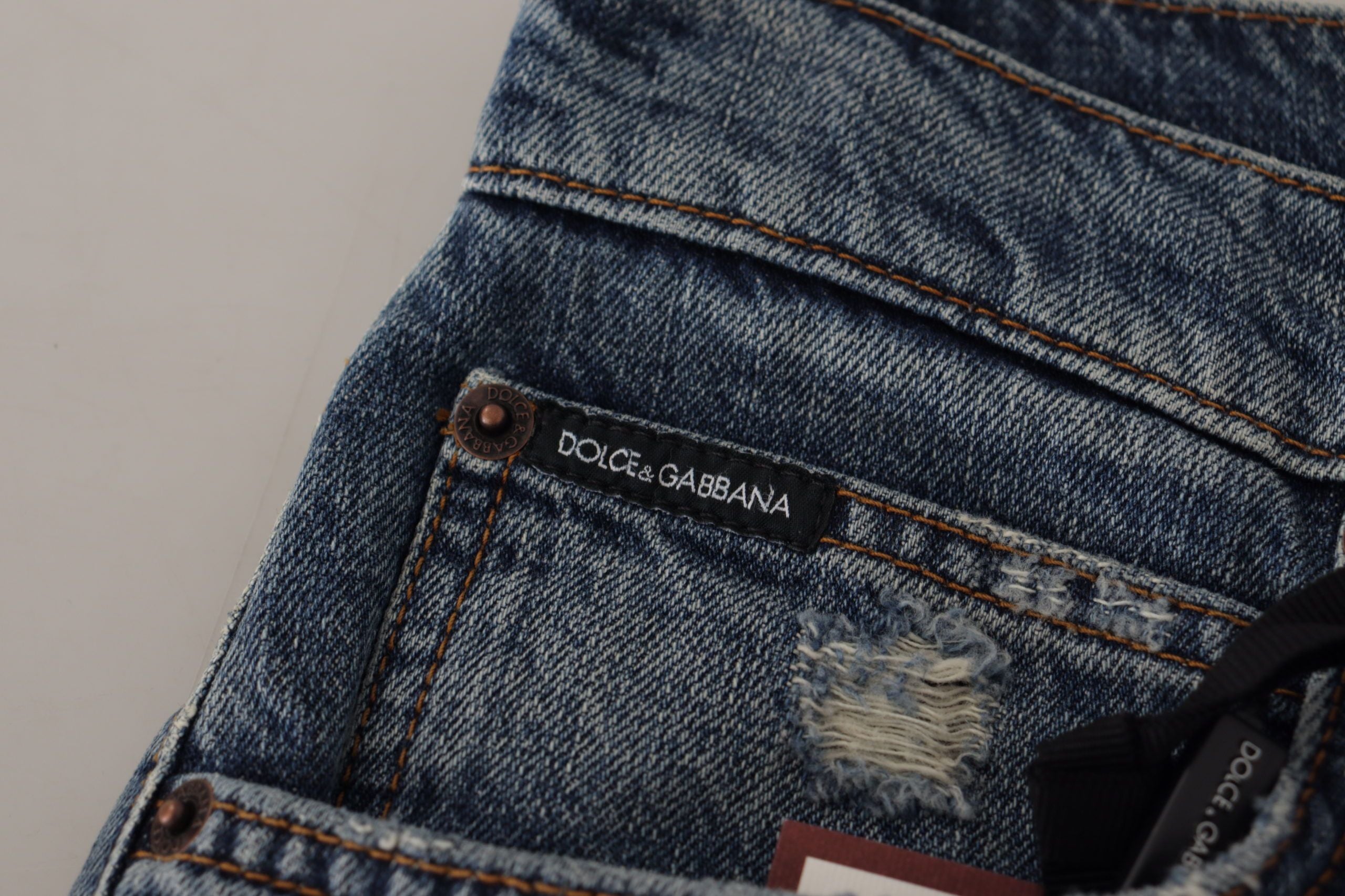 Blue denim Dolce & Gabbana jeans with baroque heart logo patch, featuring stylish design and classic fit.