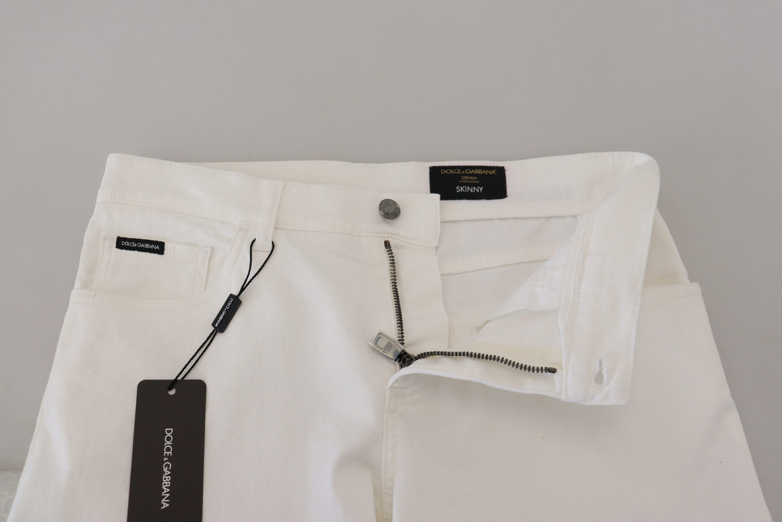 White slim skinny stretch cotton denim jeans by Dolce & Gabbana, showing close-up of fitted design and quality fabric.