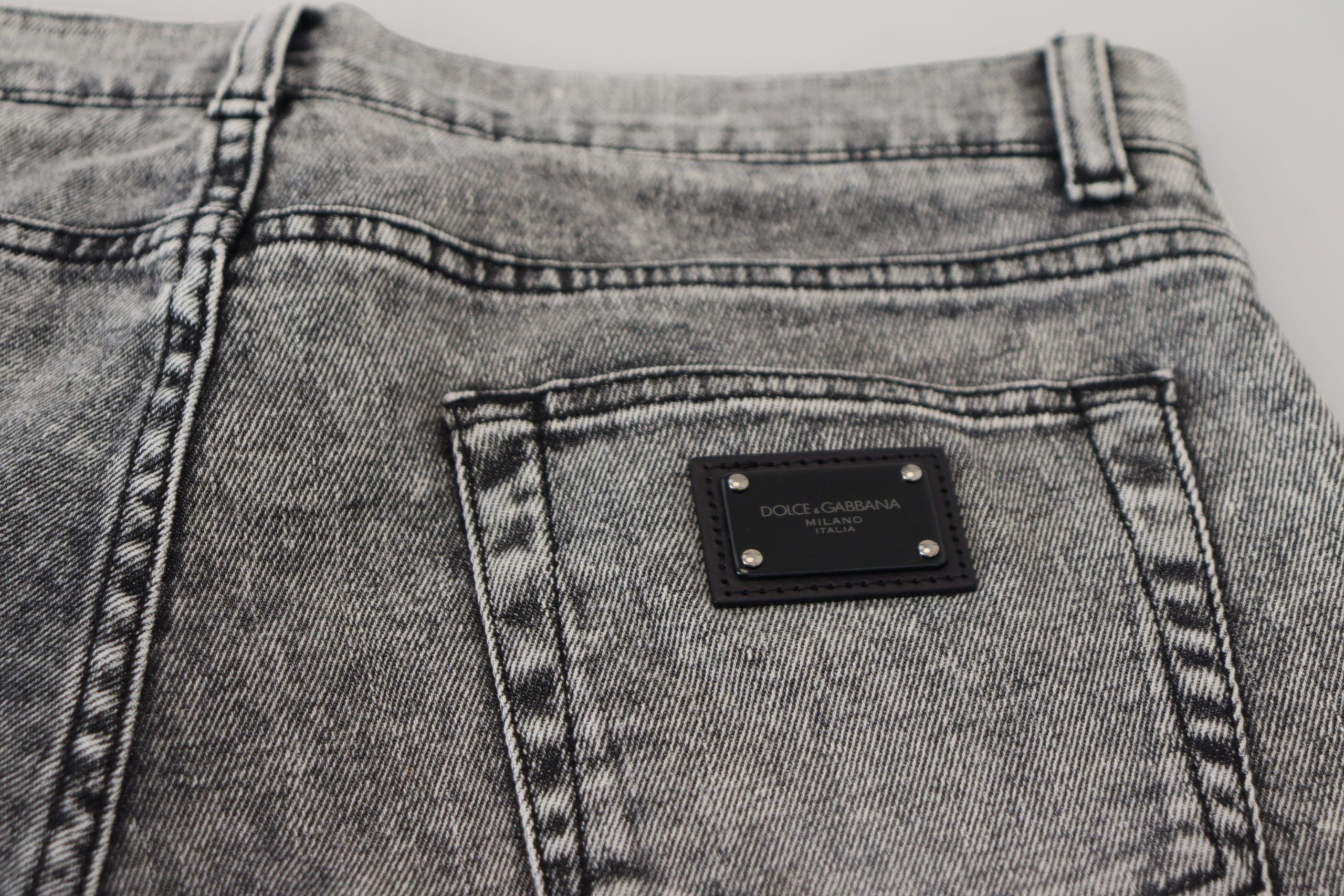 Gray slim fit stretch cotton denim jeans by Dolce & Gabbana displayed on a hanger with front and back views.
