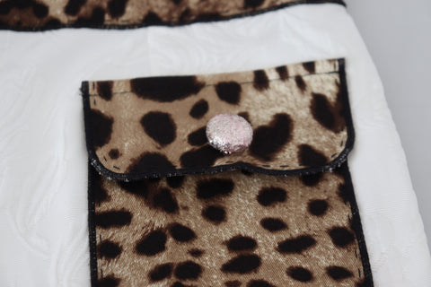 White leopard print high waist pants by Dolce & Gabbana, featuring a stylish fit and bold animal print pattern.