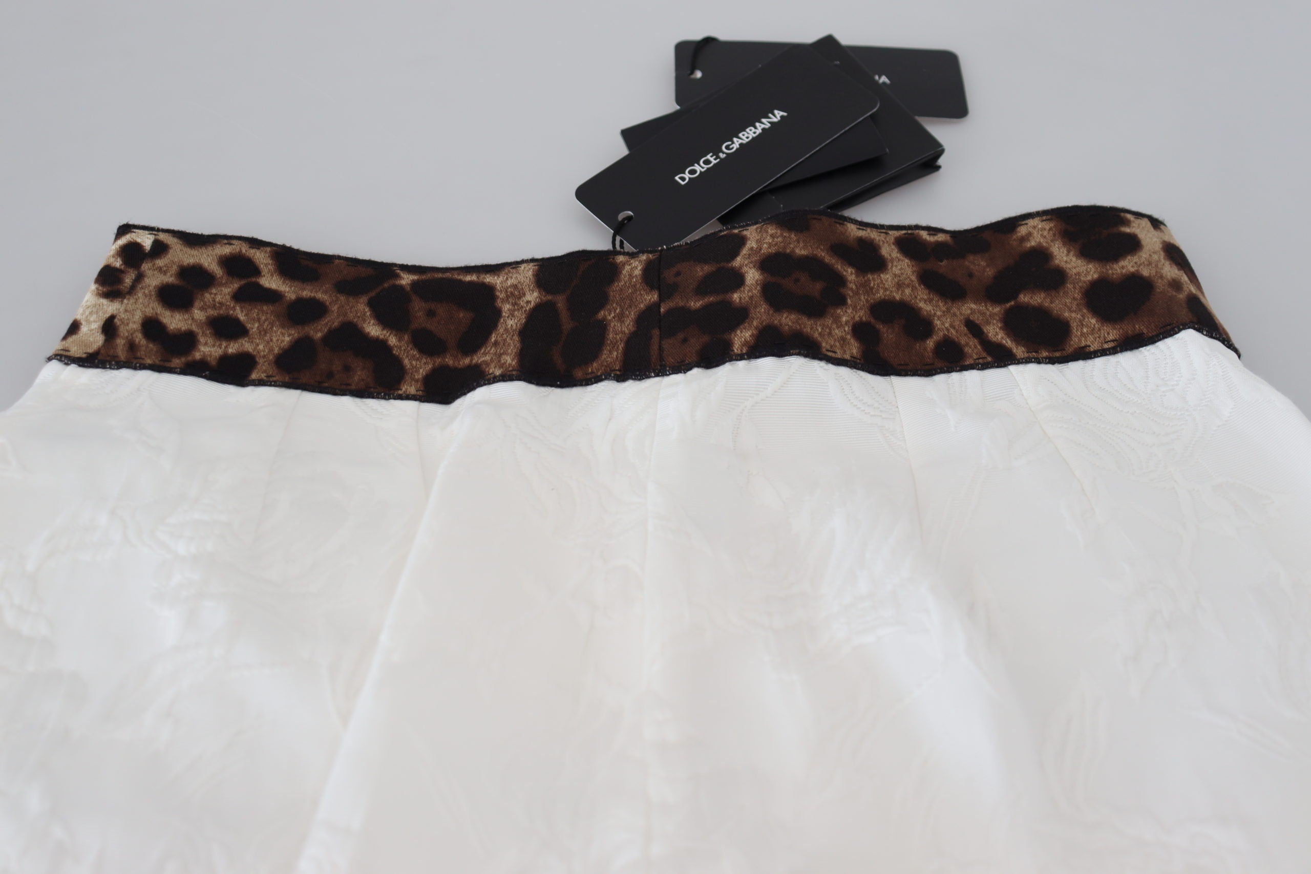 White leopard print high waist pants by Dolce & Gabbana, featuring a stylish and fitted design with a bold animal pattern.