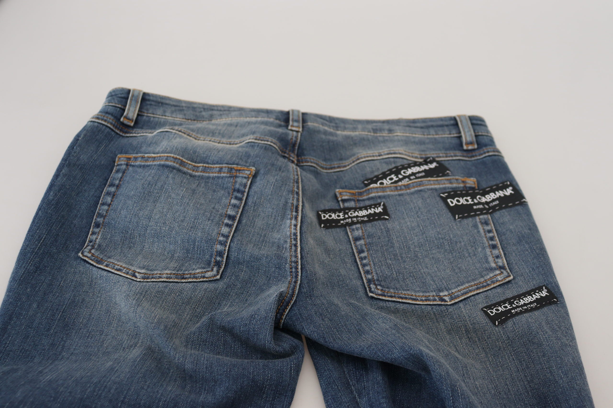 Blue washed cotton tattered denim jeans by Dolce & Gabbana with distressed details and classic five-pocket design.