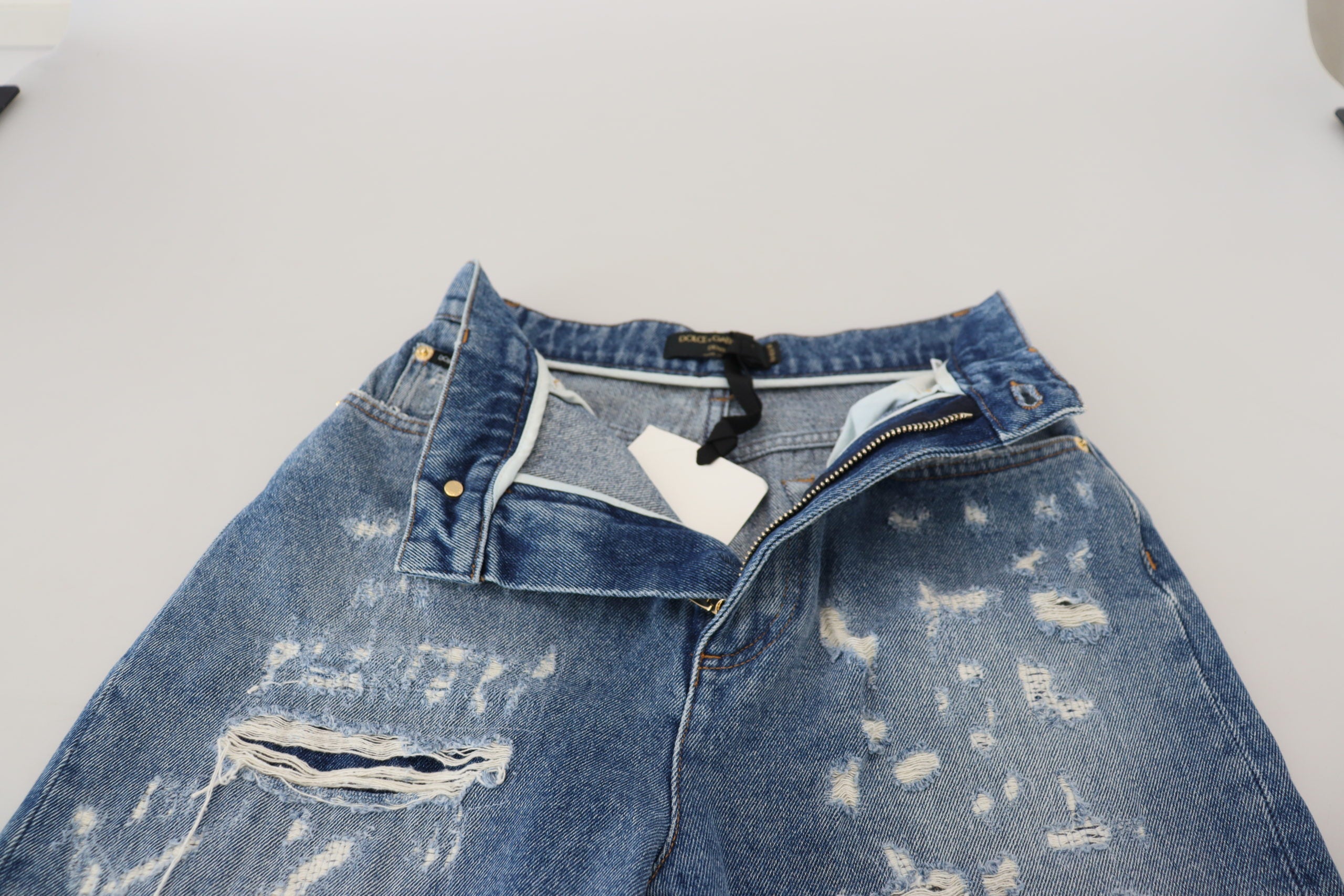 Blue washed cotton tattered denim jeans by Dolce & Gabbana, showing distressed details and classic five-pocket design.