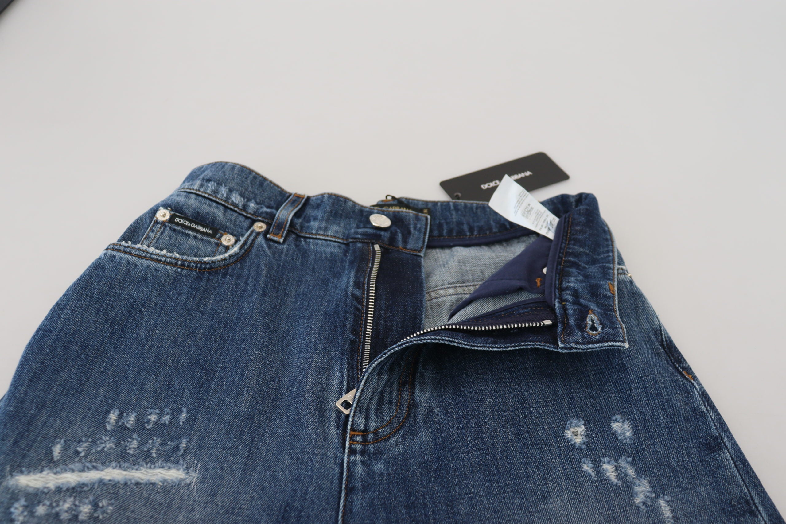 Blue washed cotton tattered denim jeans by Dolce & Gabbana, featuring distressed details and classic five-pocket design.