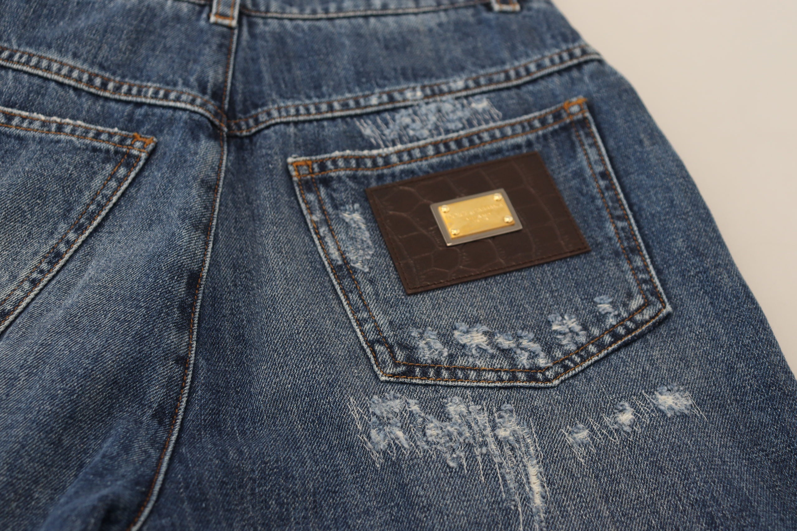 Blue washed cotton denim jeans with tattered details from Dolce & Gabbana, featuring a relaxed fit and distressed style.