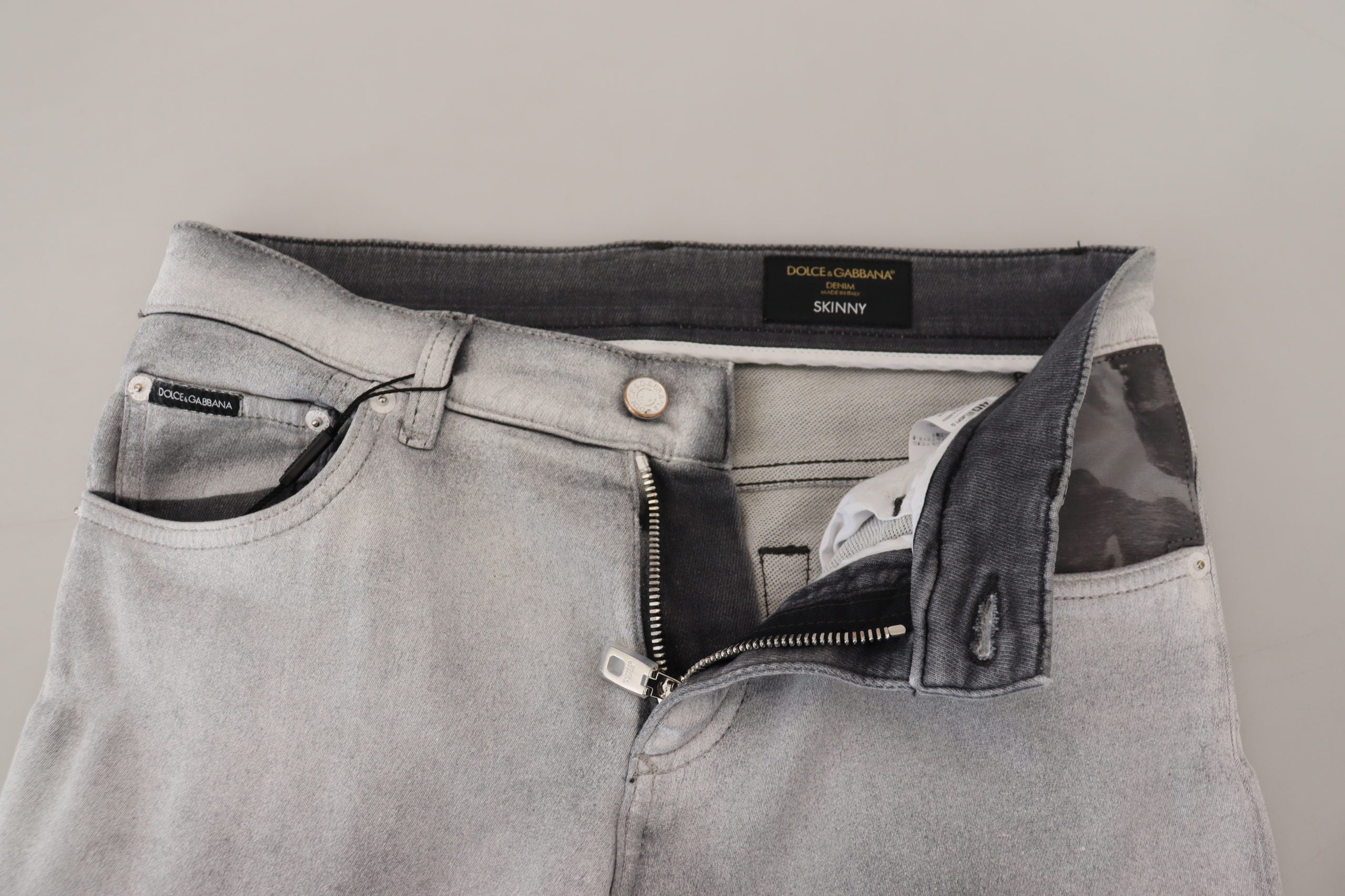 Gray washed skinny men's denim jeans by Dolce & Gabbana, showing close-up of fitted fabric and stylish design details.