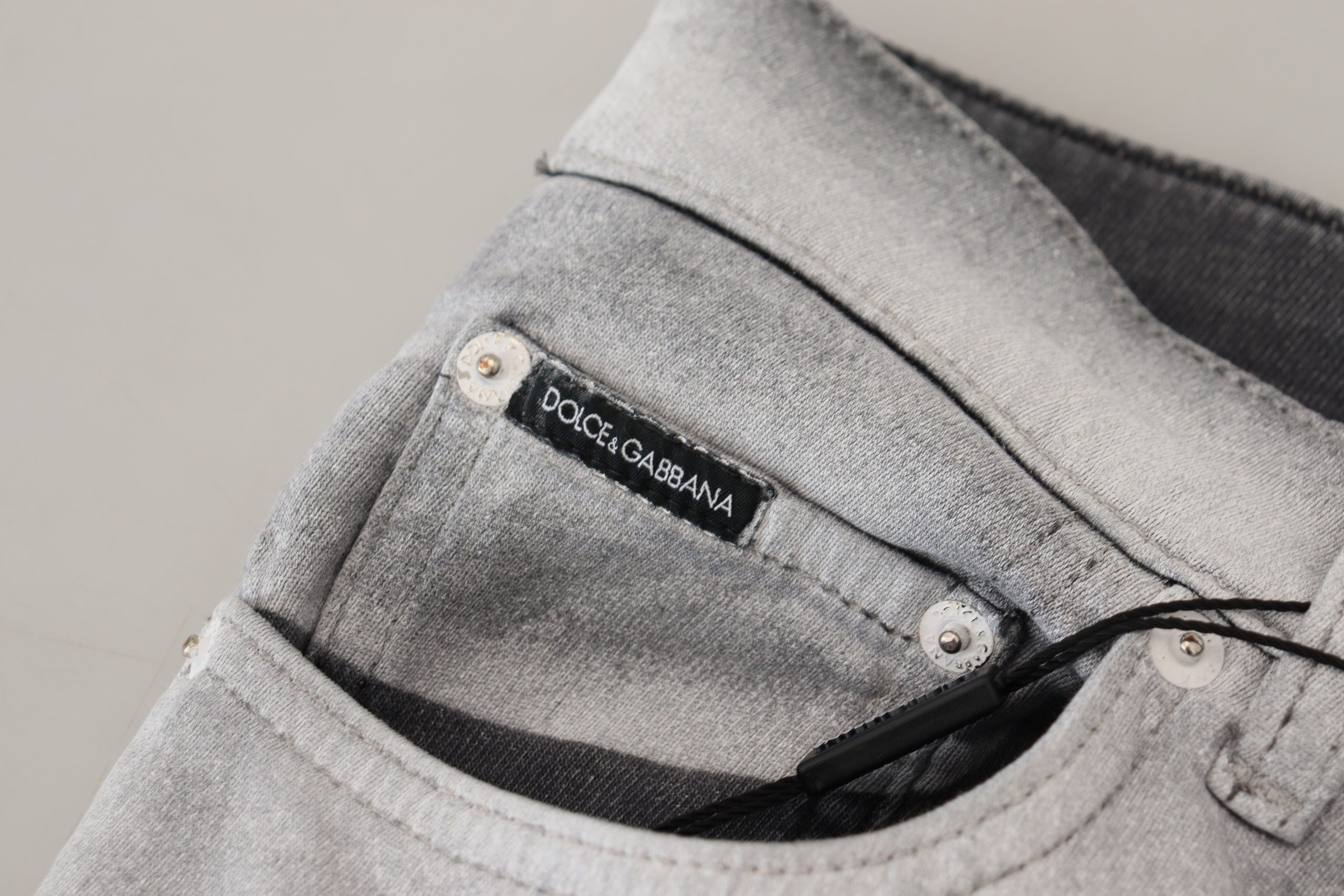 Gray washed skinny men's denim jeans by Dolce & Gabbana, showing fitted style with distressed details and classic five-pocket design.