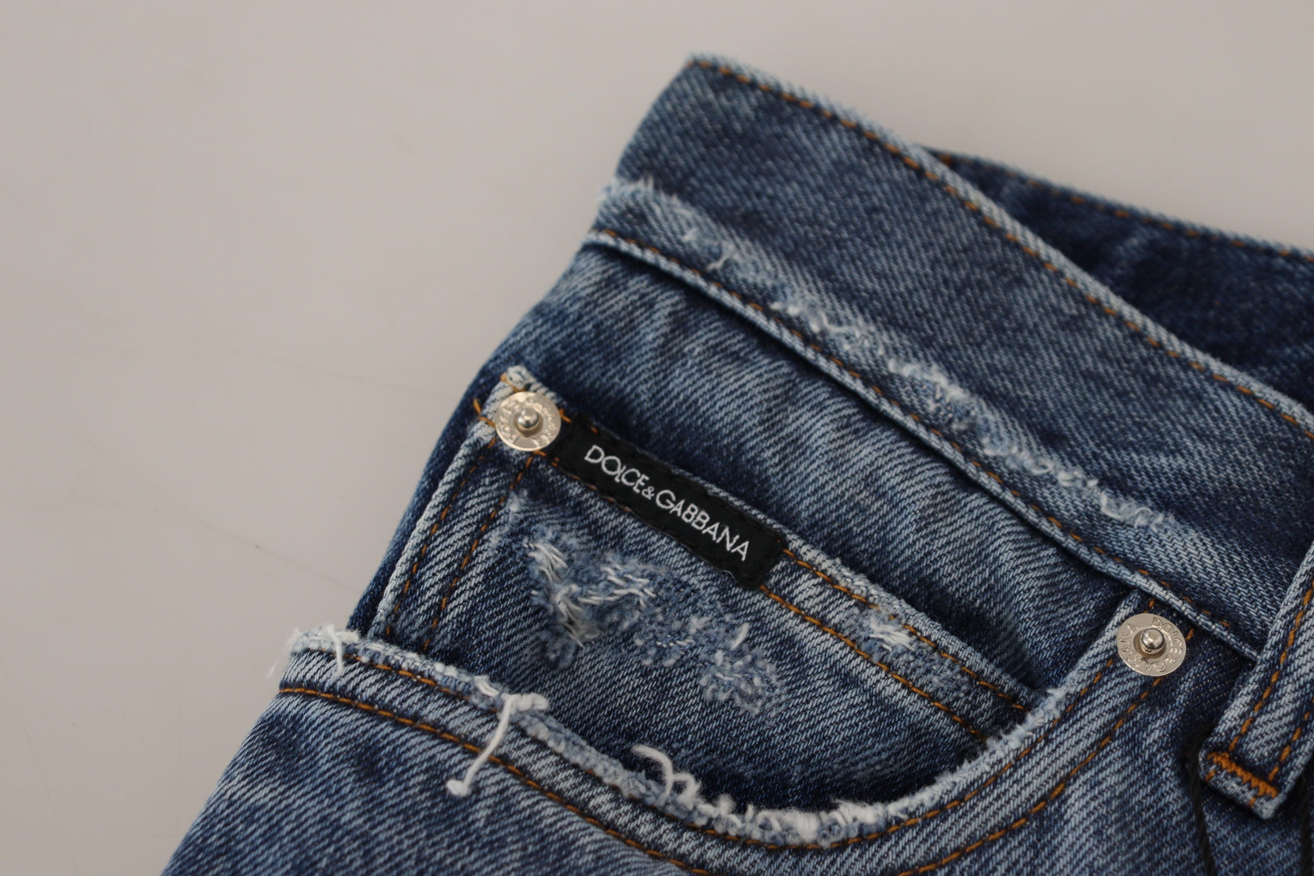 Blue cotton tattered men's denim jeans by Dolce & Gabbana, showing distressed details and classic fit.