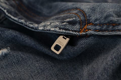 Blue cotton tattered men's denim jeans by Dolce & Gabbana with distressed details and classic fit.