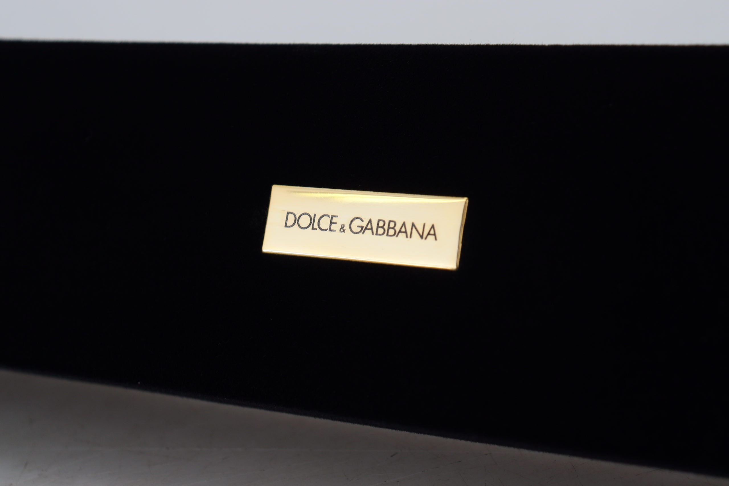 Black velvet jewelry box with Dolce & Gabbana logo plaque, designed for storing bracelets and jewelry accessories.