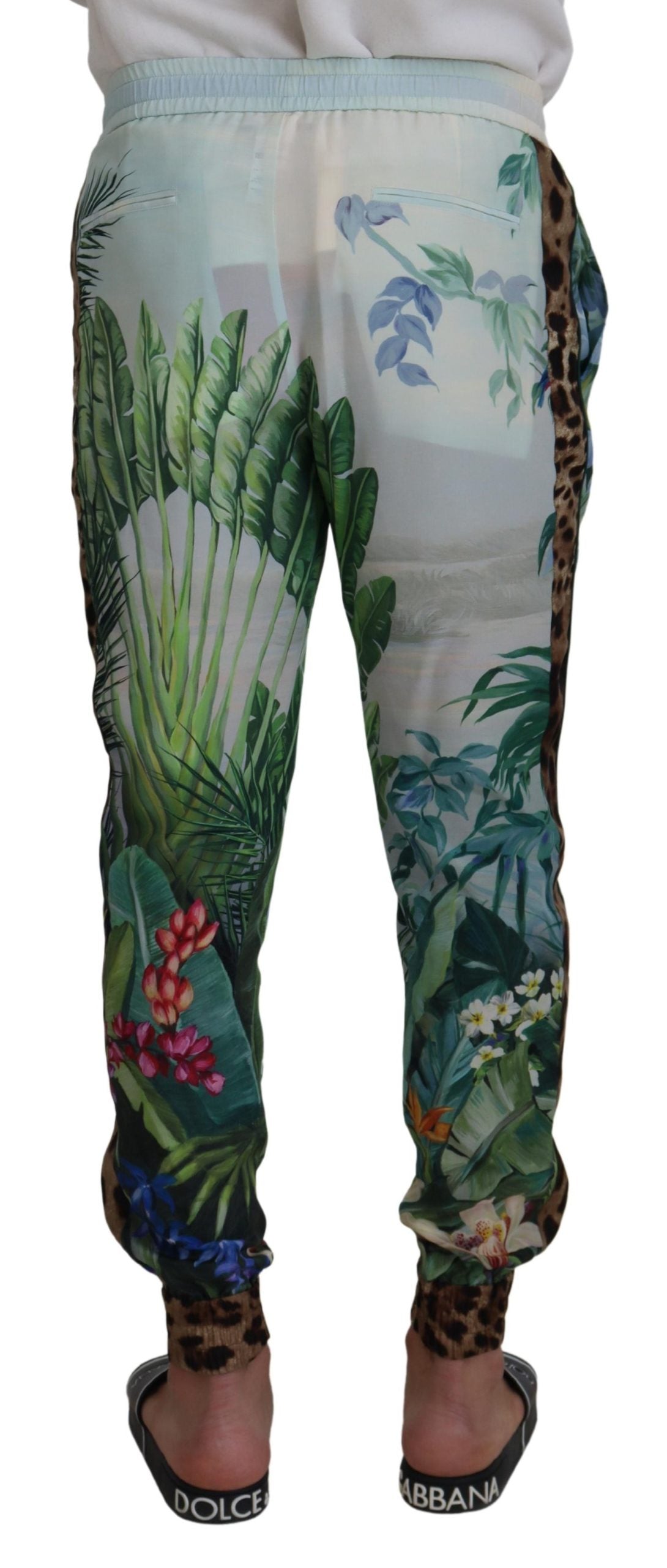 White floral printed men jogger pants by Dolce & Gabbana with elastic waistband and tapered fit, featuring vibrant floral design.