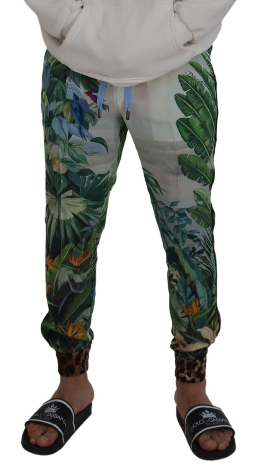 White floral printed men's jogger pants by Dolce & Gabbana with a relaxed fit and floral design, shown on a model.