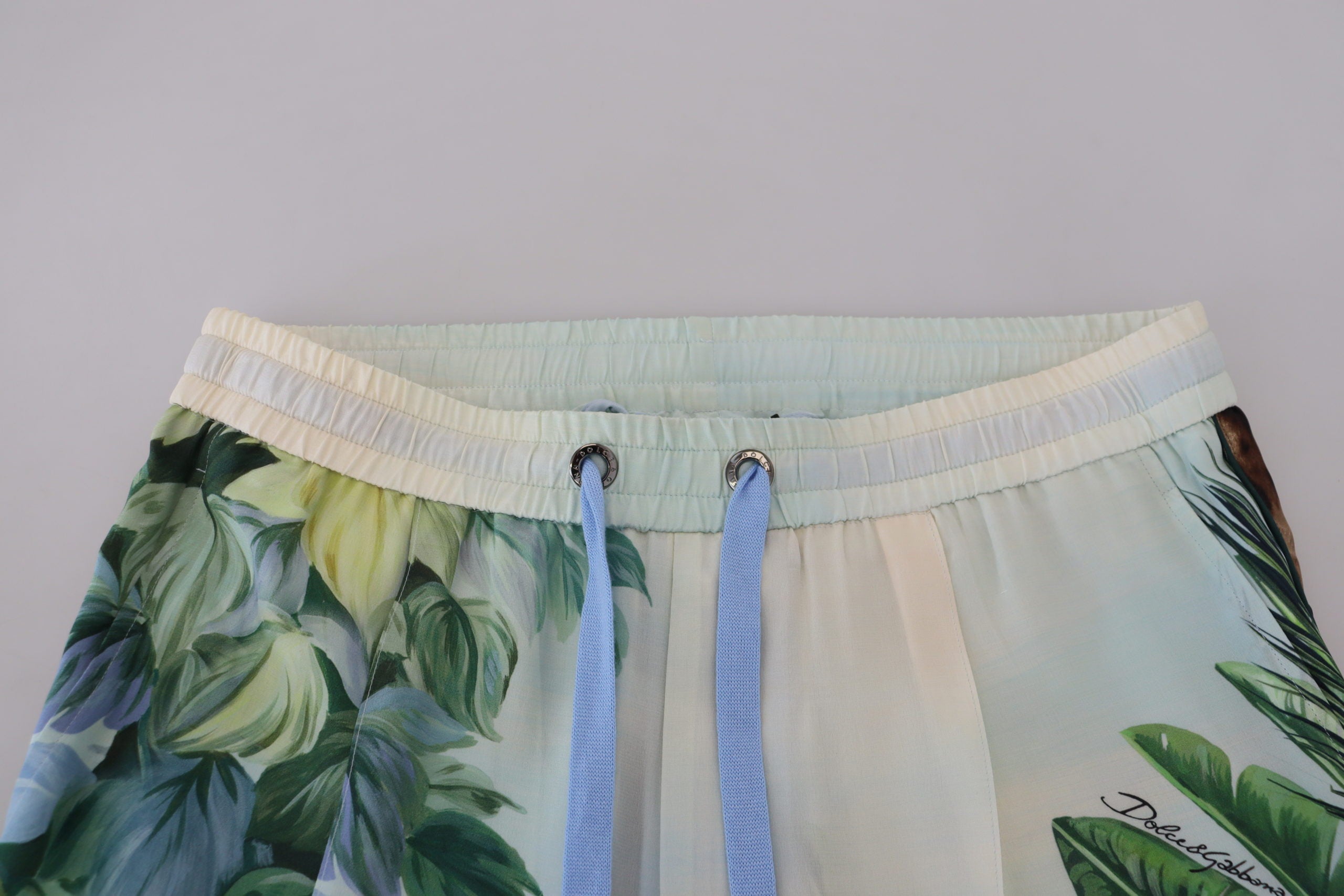 White floral printed men's jogger pants by Dolce & Gabbana with relaxed fit and floral pattern, casual streetwear style.