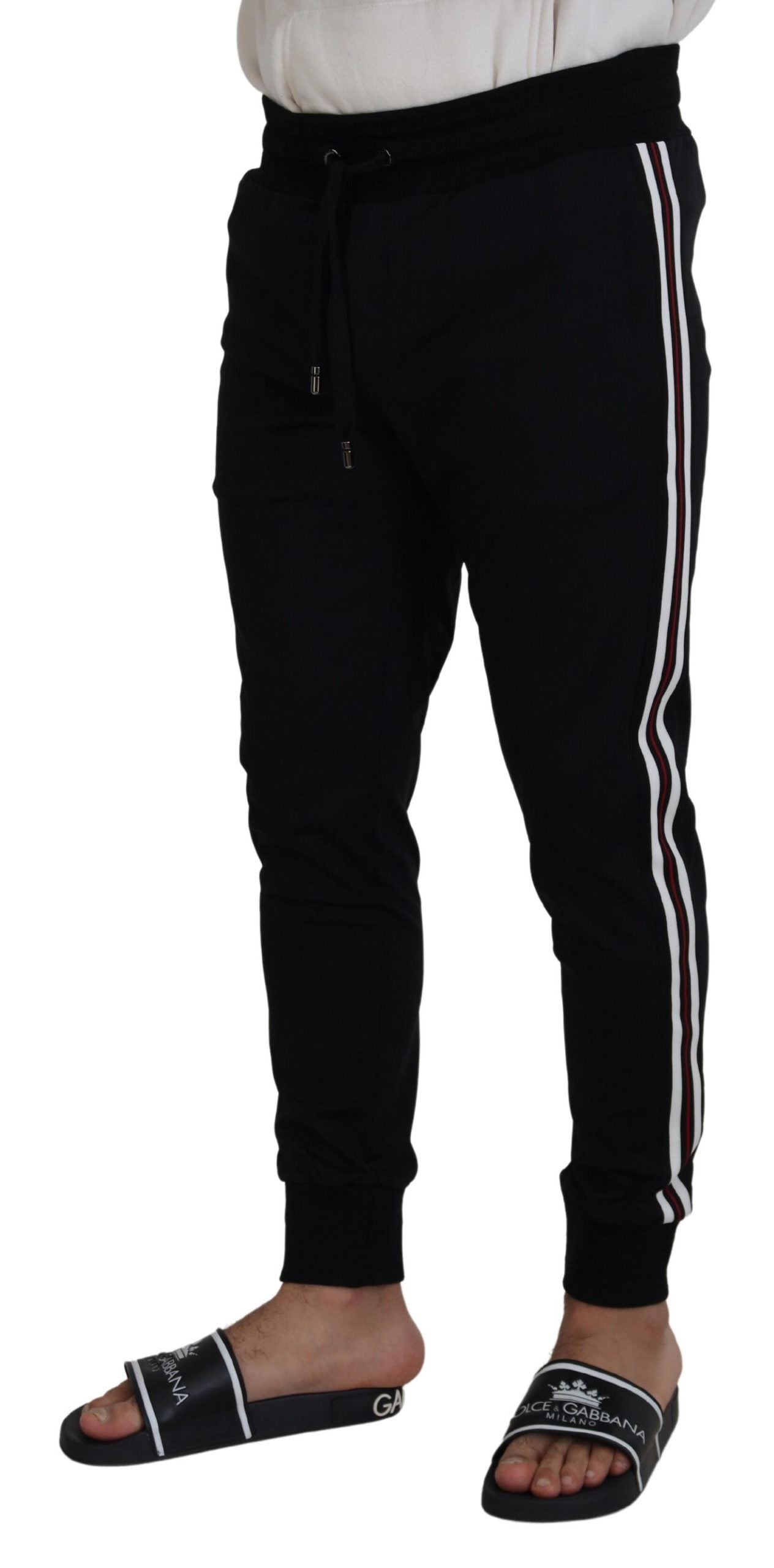 Black DG print men's jogger pants by Dolce & Gabbana with tapered fit and elastic waistband, casual streetwear style.