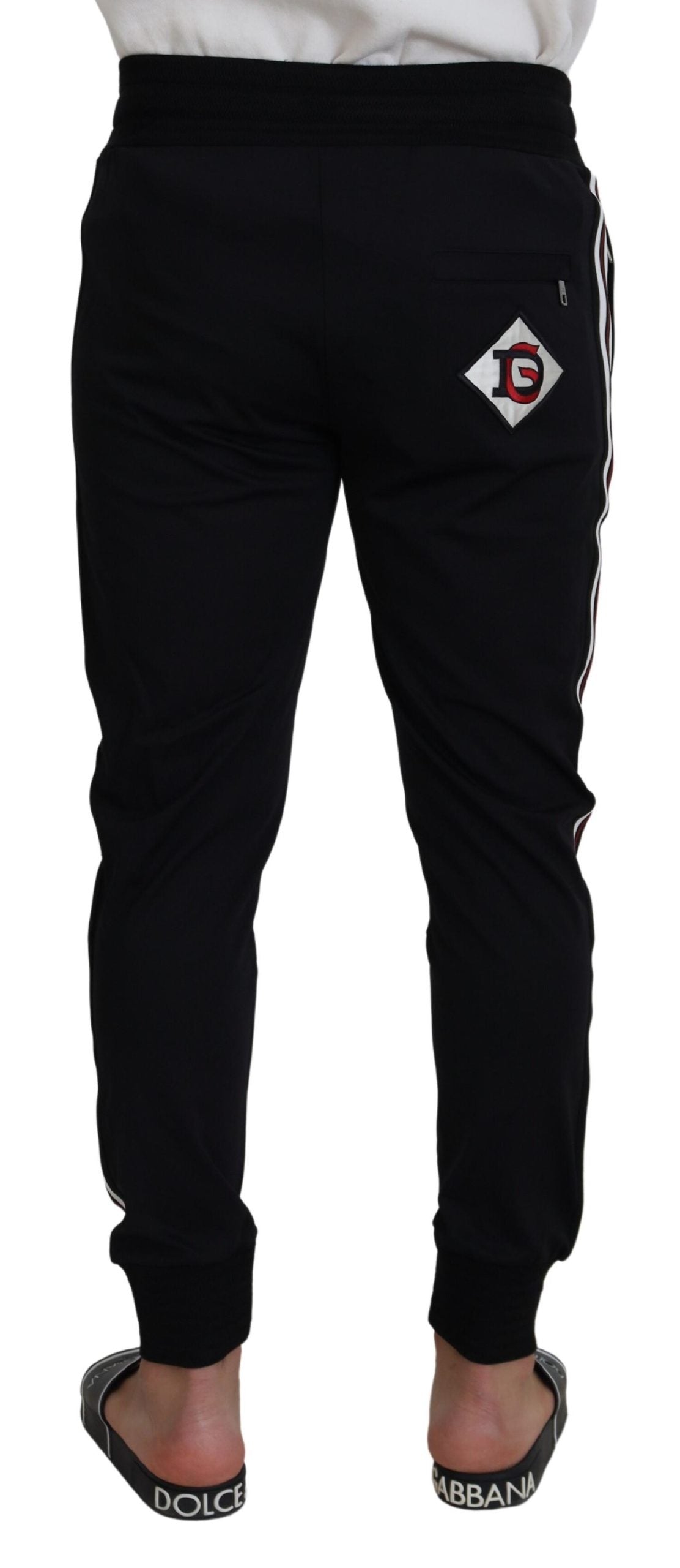 Black Dolce & Gabbana print men's jogger pants with tapered fit and elastic waistband, shown on a model.