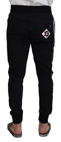 Black Dolce & Gabbana print men's jogger pants with tapered fit and elastic waistband, shown on a model.