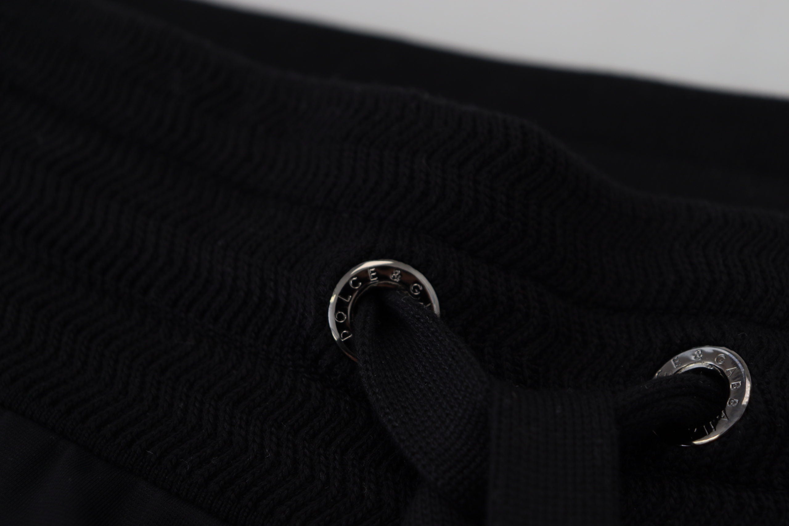 Black Dolce & Gabbana men's jogger pants with DG print, featuring a relaxed fit and elastic waistband, shown on a plain background.