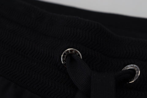 Black Dolce & Gabbana men's jogger pants with DG print, featuring a relaxed fit and elastic waistband, shown on a plain background.