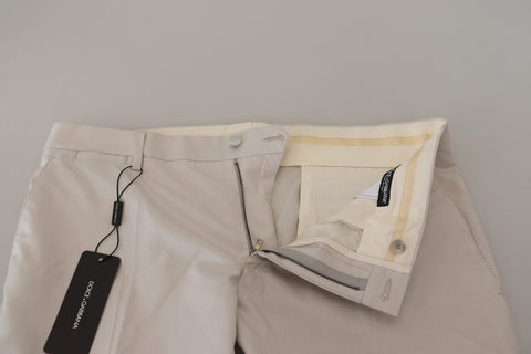 Off White silk mid-waist chino pants by Dolce & Gabbana laid flat showing front and side views.