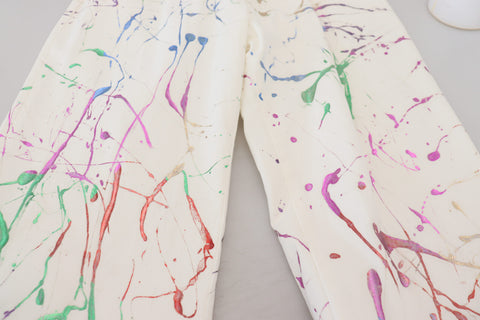 White cotton denim pants with colorful splash print by Dolce & Gabbana, featuring a relaxed fit and casual style.