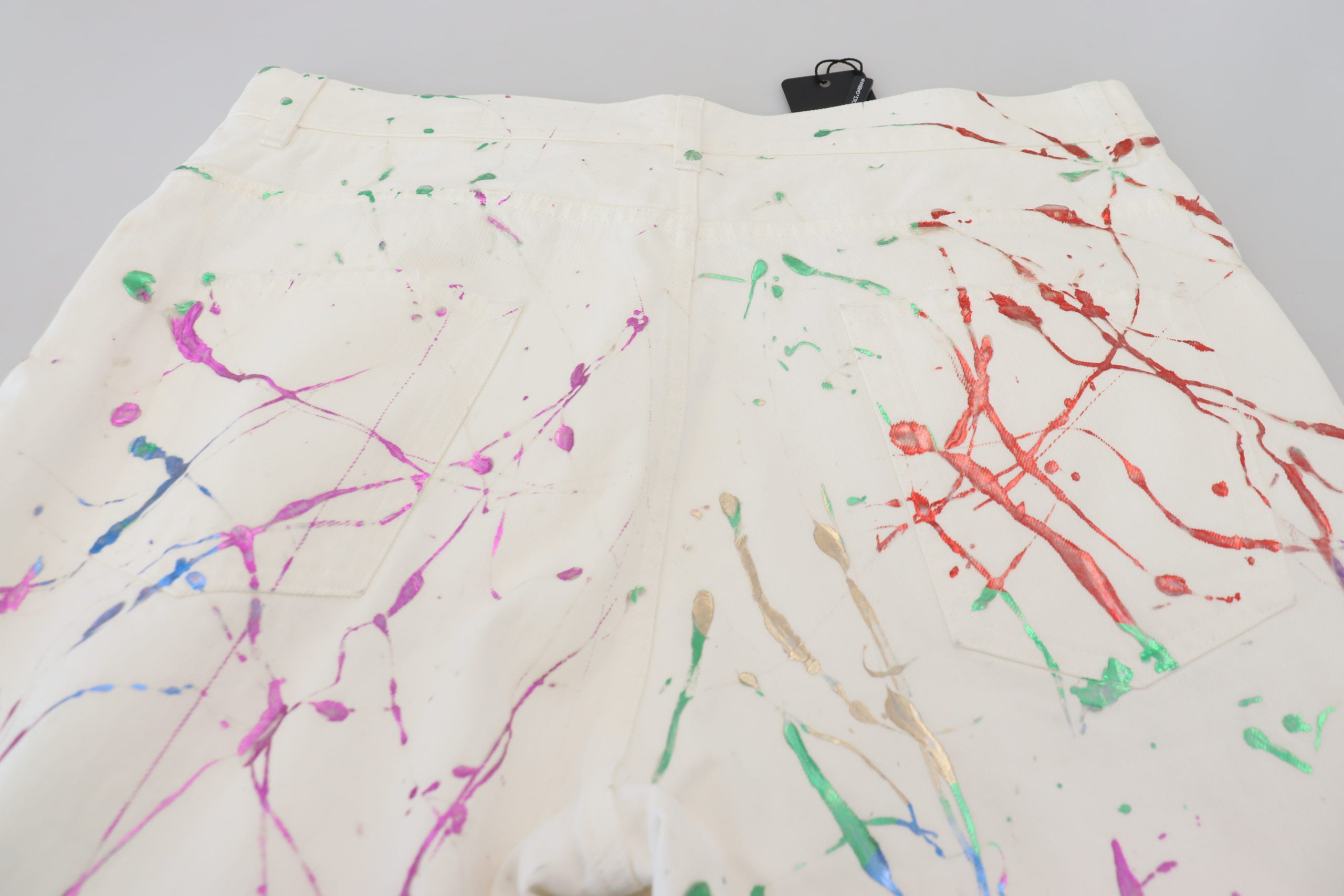White cotton denim pants with colorful splash print by Dolce & Gabbana, featuring a stylish, casual fit and classic five-pocket design.