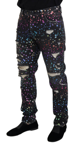 Black multicolor print tattered denim jeans by Dolce & Gabbana with distressed details and vibrant multicolor pattern.