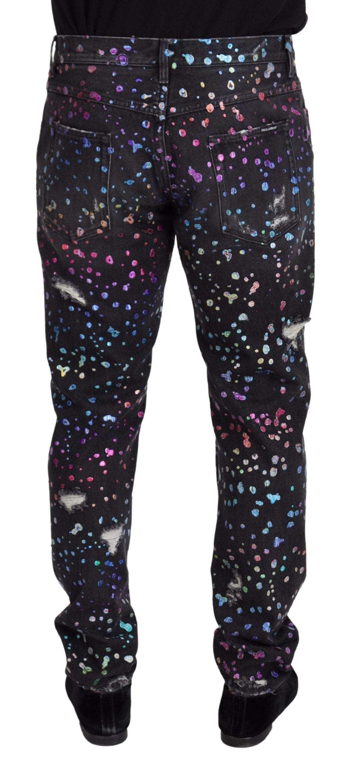 Black multicolor print tattered denim jeans by Dolce & Gabbana, featuring distressed details and vibrant fabric patterns.
