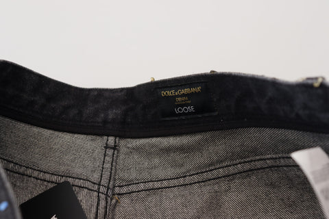 Black multicolor print tattered denim jeans by Dolce & Gabbana, featuring distressed details and vibrant floral patterns.
