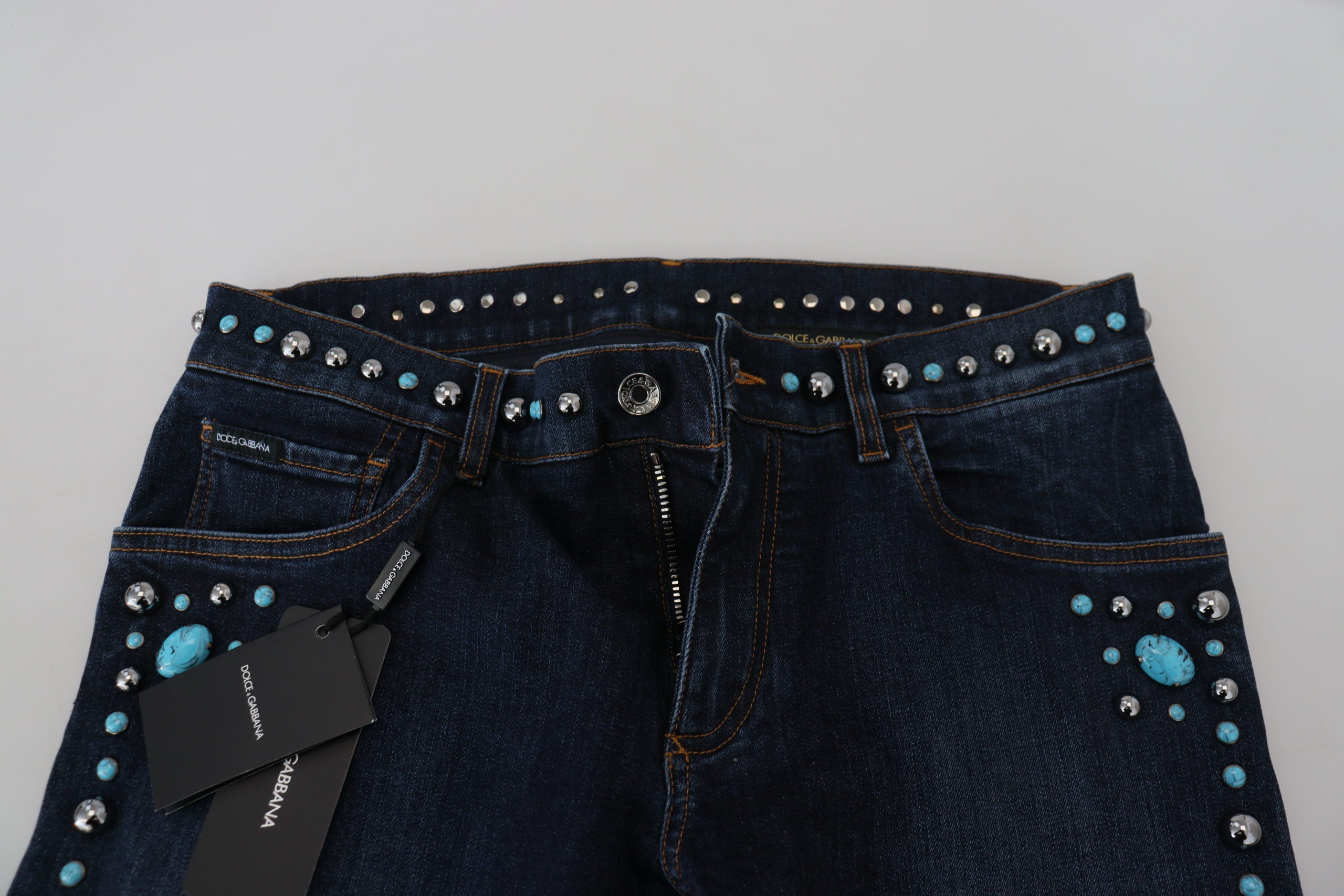 Blue cotton studded low waist denim jeans by Dolce & Gabbana, showing front view with studded details and classic five-pocket design.