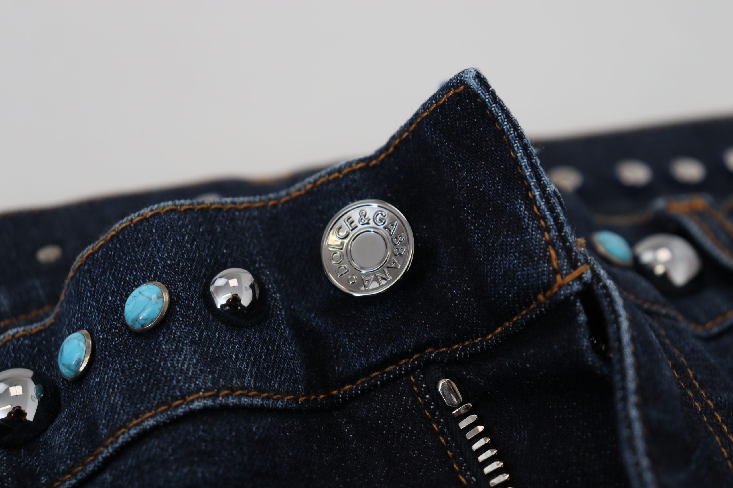 Blue cotton studded low waist denim jeans by Dolce & Gabbana, showing close-up of the front with silver stud accents and belt loops.