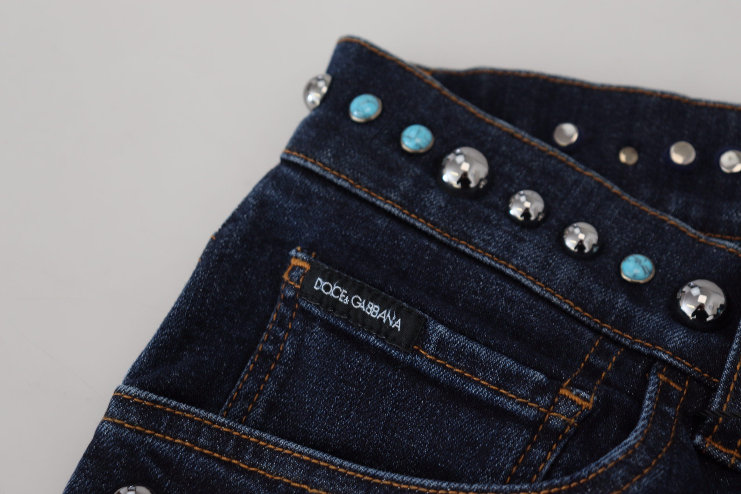 Blue cotton studded low waist denim jeans by Dolce & Gabbana, showing front view with stud embellishments and slim fit cut.