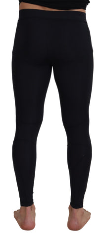 Black nylon slim fit stretch pants by Dolce & Gabbana, shown on a model with a close-up of the tailored design and waistband.
