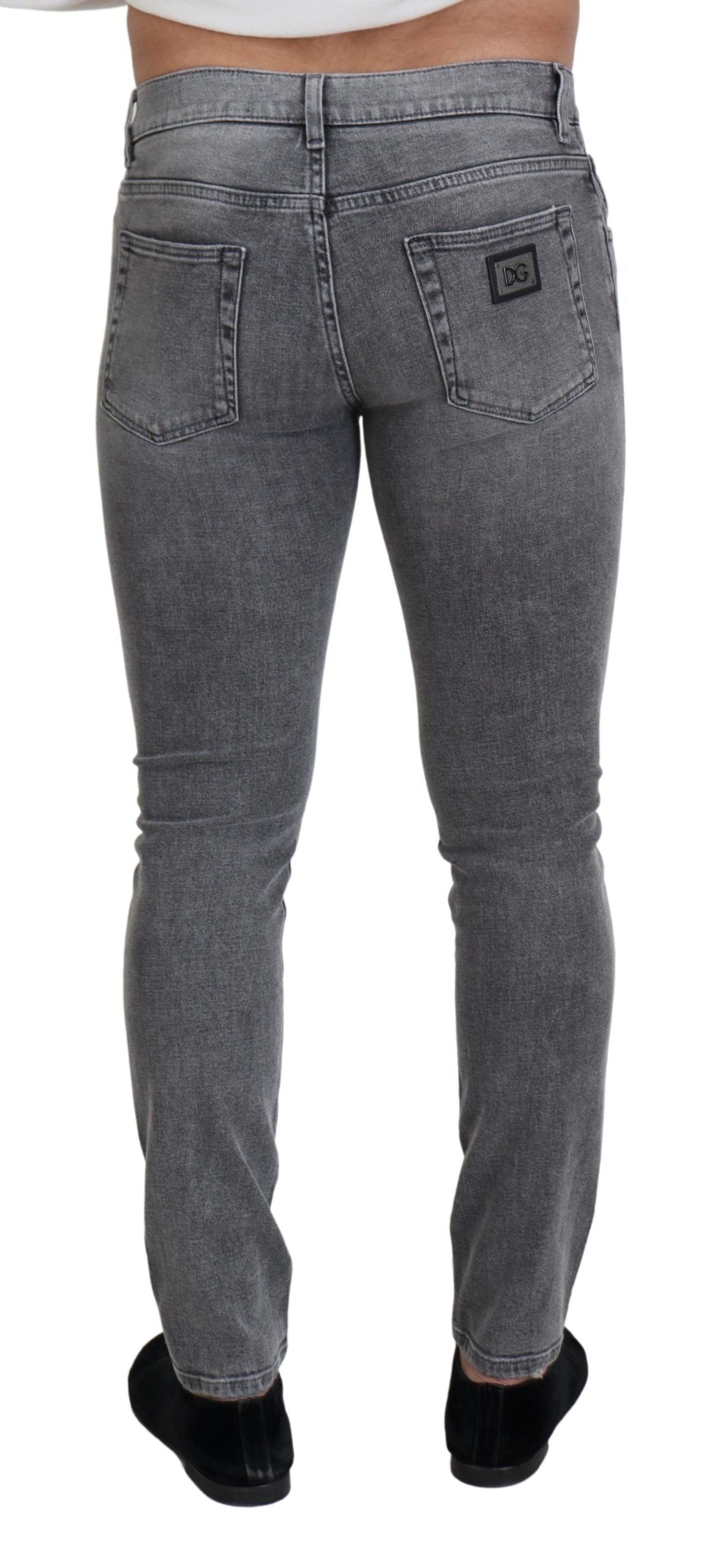 Grey washed cotton skinny denim jeans by Dolce & Gabbana displayed on a hanger with visible stitching and classic five-pocket design.